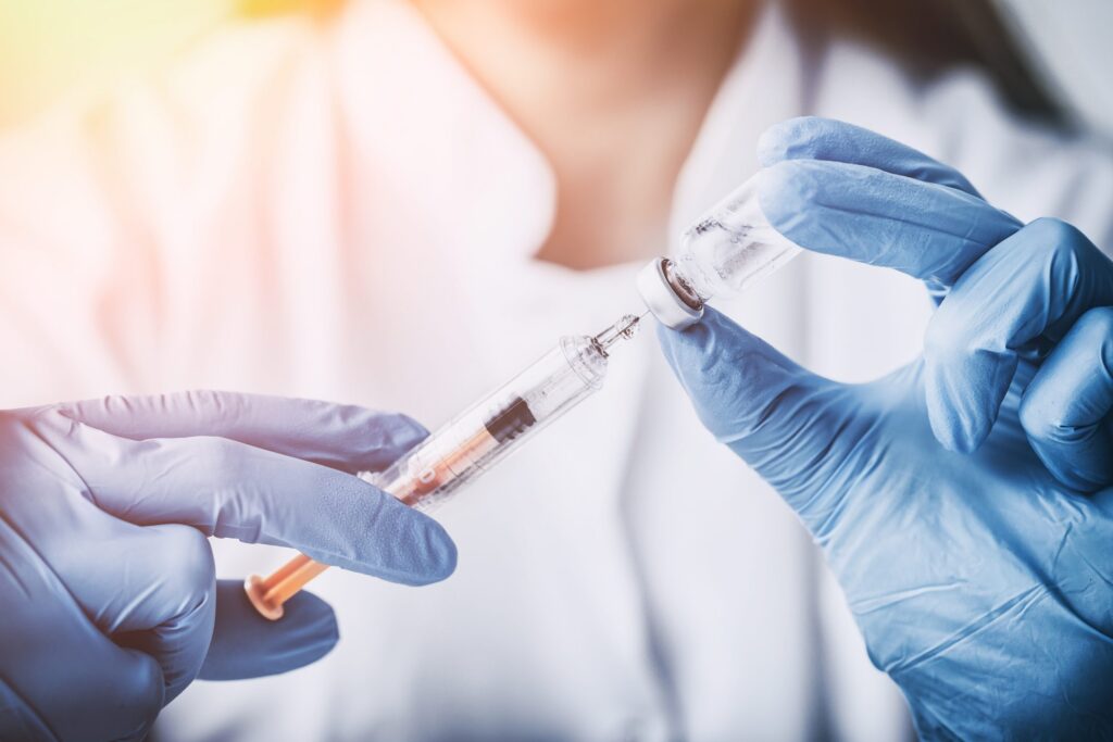 closeup of hypodermic needle drawing medicine