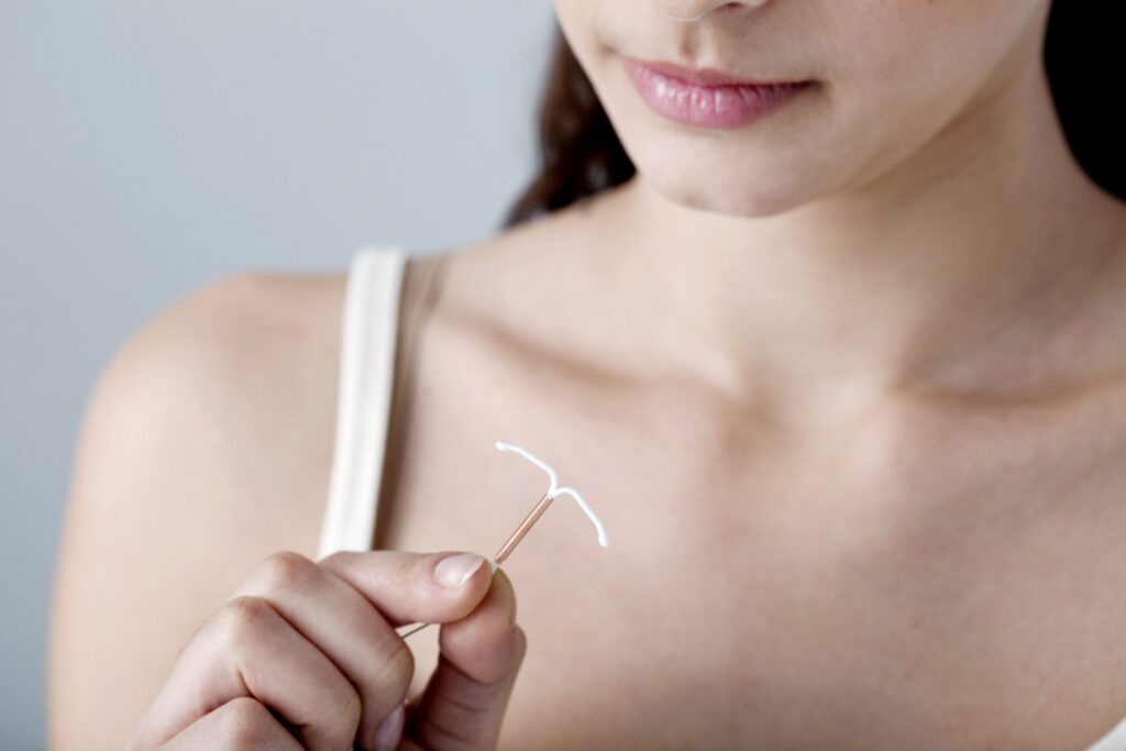 closeup of woman holding IUD