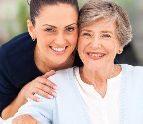 smiling nurse looking over shoulder of smiling senior patient