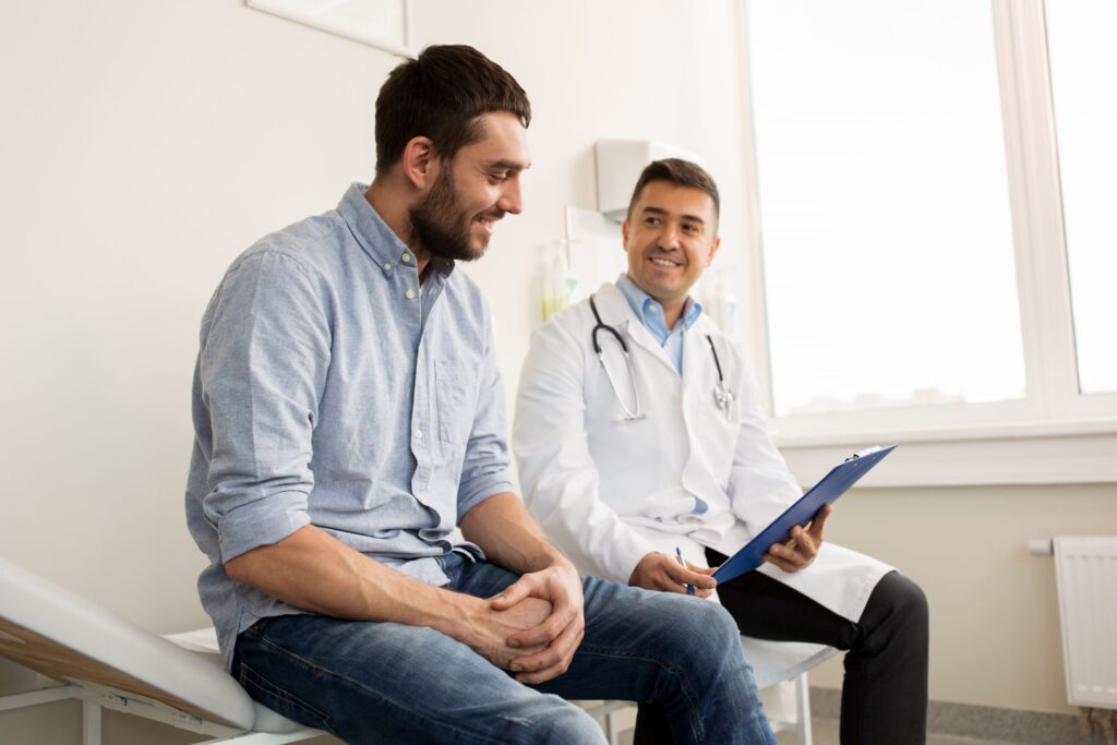 smiling male patient and physician looking at medical charts