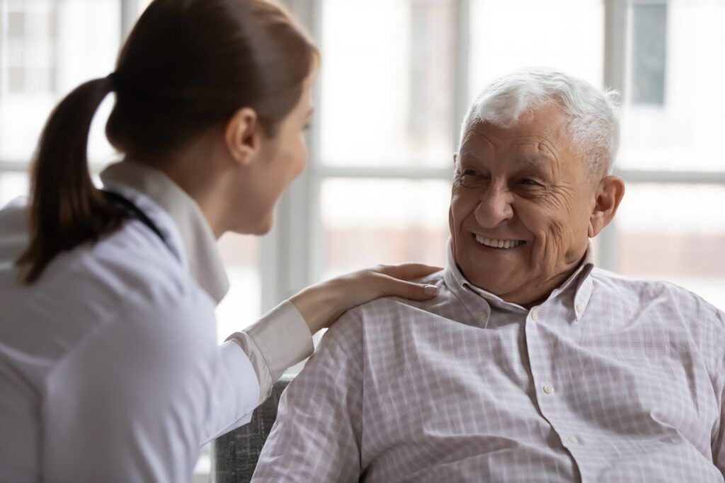 female physician comforting smiling senior male patient