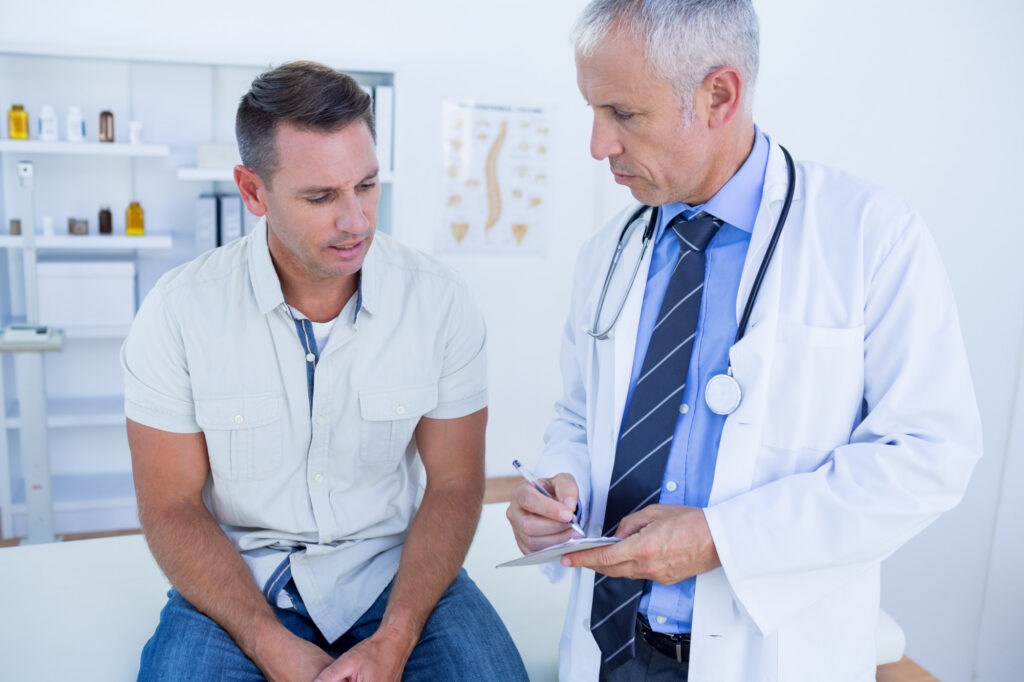 smiling male patient and physician looking at medical charts